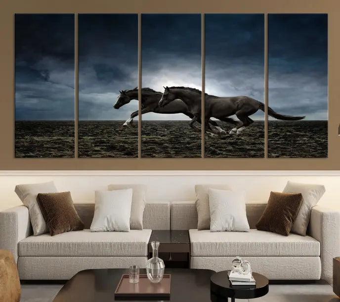 The Wild Horses Wall Art Canvas Print features a triptych of two galloping black horses set against a dark, cloudy landscape. This piece is gallery-wrapped on museum-quality canvas.