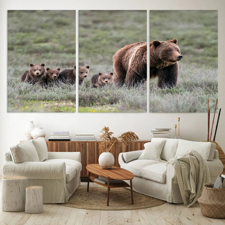 The canvas wall art print, titled "Queen of the Tetons," features a photo of 399 grizzly bear cubs walking with a larger bear in a green, open field. This striking piece is framed and leaning against a wall, showcasing its gallery-quality finish.