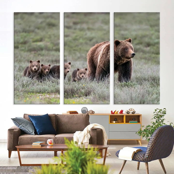 The canvas wall art print, titled "Queen of the Tetons," features a photo of 399 grizzly bear cubs walking with a larger bear in a green, open field. This striking piece is framed and leaning against a wall, showcasing its gallery-quality finish.