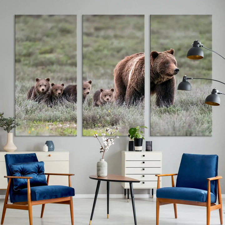 The canvas wall art print, titled "Queen of the Tetons," features a photo of 399 grizzly bear cubs walking with a larger bear in a green, open field. This striking piece is framed and leaning against a wall, showcasing its gallery-quality finish.