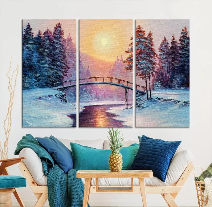 The "Winter Bridge Painting Wall Art Landscape Canvas Print" captures a serene winter landscape across three panels, showcasing a bridge, snowy trees, and a setting sun on museum-quality canvases. Each piece is gallery wrapped for an elegant finish that enhances the tranquility of the scene.