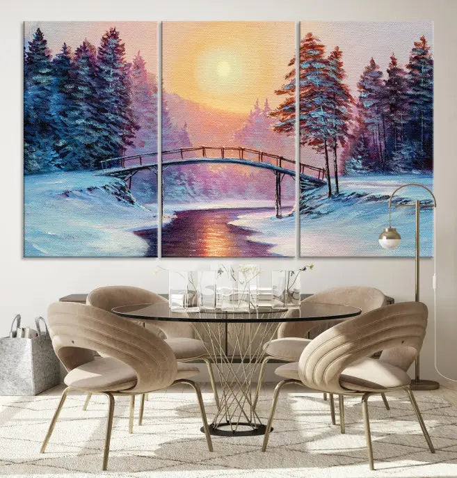 The "Winter Bridge Painting Wall Art Landscape Canvas Print" captures a serene winter landscape across three panels, showcasing a bridge, snowy trees, and a setting sun on museum-quality canvases. Each piece is gallery wrapped for an elegant finish that enhances the tranquility of the scene.