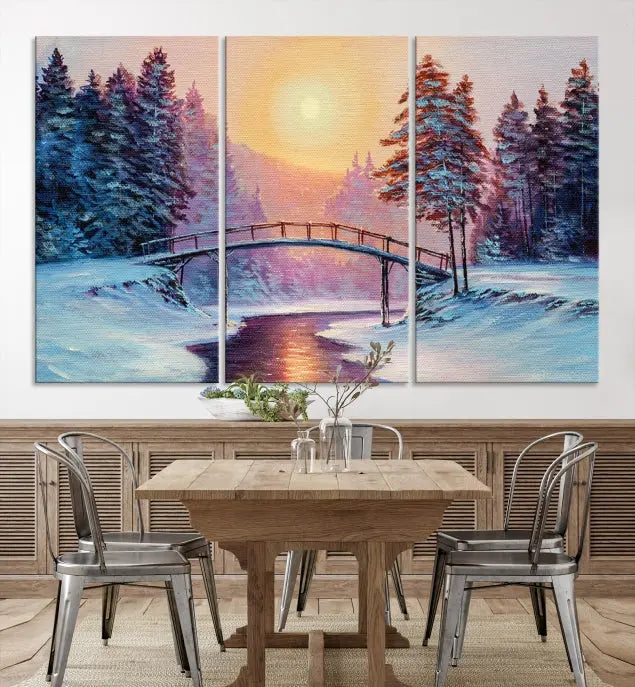 The "Winter Bridge Painting Wall Art Landscape Canvas Print" captures a serene winter landscape across three panels, showcasing a bridge, snowy trees, and a setting sun on museum-quality canvases. Each piece is gallery wrapped for an elegant finish that enhances the tranquility of the scene.