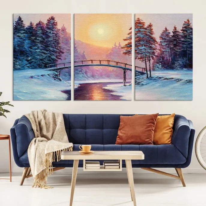 The "Winter Bridge Painting Wall Art Landscape Canvas Print" captures a serene winter landscape across three panels, showcasing a bridge, snowy trees, and a setting sun on museum-quality canvases. Each piece is gallery wrapped for an elegant finish that enhances the tranquility of the scene.