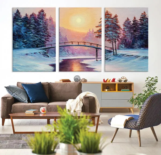 The "Winter Bridge Painting Wall Art Landscape Canvas Print" captures a serene winter landscape across three panels, showcasing a bridge, snowy trees, and a setting sun on museum-quality canvases. Each piece is gallery wrapped for an elegant finish that enhances the tranquility of the scene.