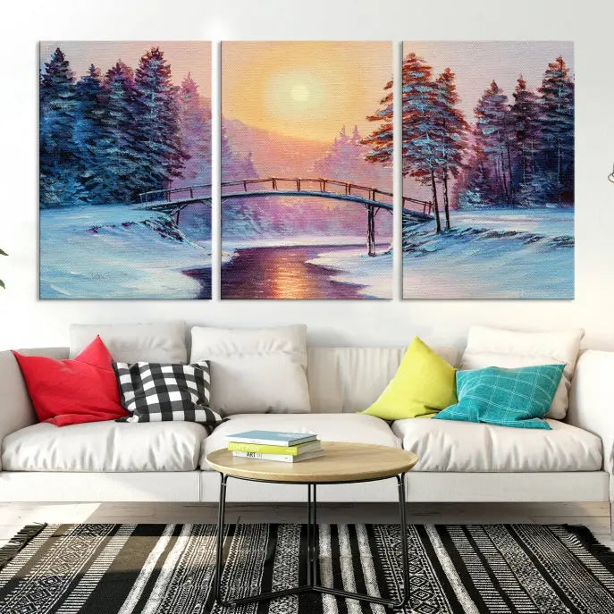 The "Winter Bridge Painting Wall Art Landscape Canvas Print" captures a serene winter landscape across three panels, showcasing a bridge, snowy trees, and a setting sun on museum-quality canvases. Each piece is gallery wrapped for an elegant finish that enhances the tranquility of the scene.