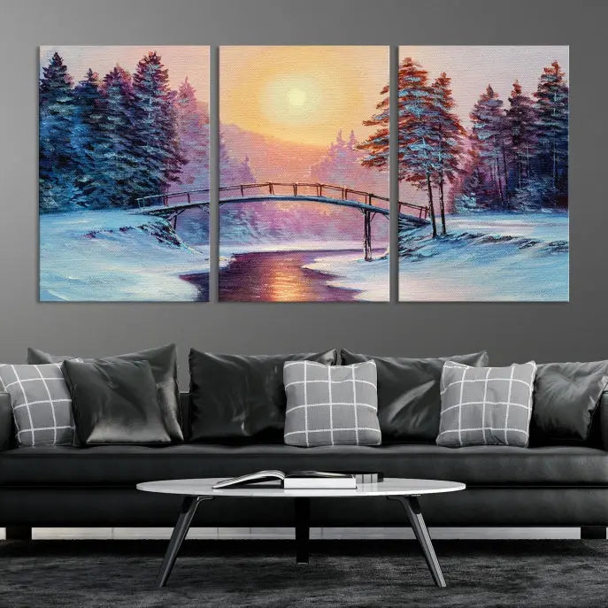 The "Winter Bridge Painting Wall Art Landscape Canvas Print" captures a serene winter landscape across three panels, showcasing a bridge, snowy trees, and a setting sun on museum-quality canvases. Each piece is gallery wrapped for an elegant finish that enhances the tranquility of the scene.