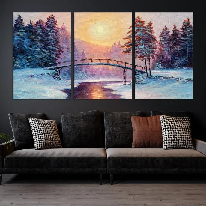 The "Winter Bridge Painting Wall Art Landscape Canvas Print" captures a serene winter landscape across three panels, showcasing a bridge, snowy trees, and a setting sun on museum-quality canvases. Each piece is gallery wrapped for an elegant finish that enhances the tranquility of the scene.