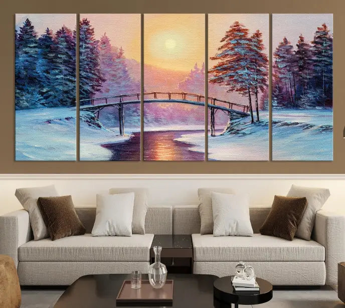 The "Winter Bridge Painting Wall Art Landscape Canvas Print" captures a serene winter landscape across three panels, showcasing a bridge, snowy trees, and a setting sun on museum-quality canvases. Each piece is gallery wrapped for an elegant finish that enhances the tranquility of the scene.