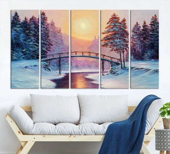 The "Winter Bridge Painting Wall Art Landscape Canvas Print" captures a serene winter landscape across three panels, showcasing a bridge, snowy trees, and a setting sun on museum-quality canvases. Each piece is gallery wrapped for an elegant finish that enhances the tranquility of the scene.