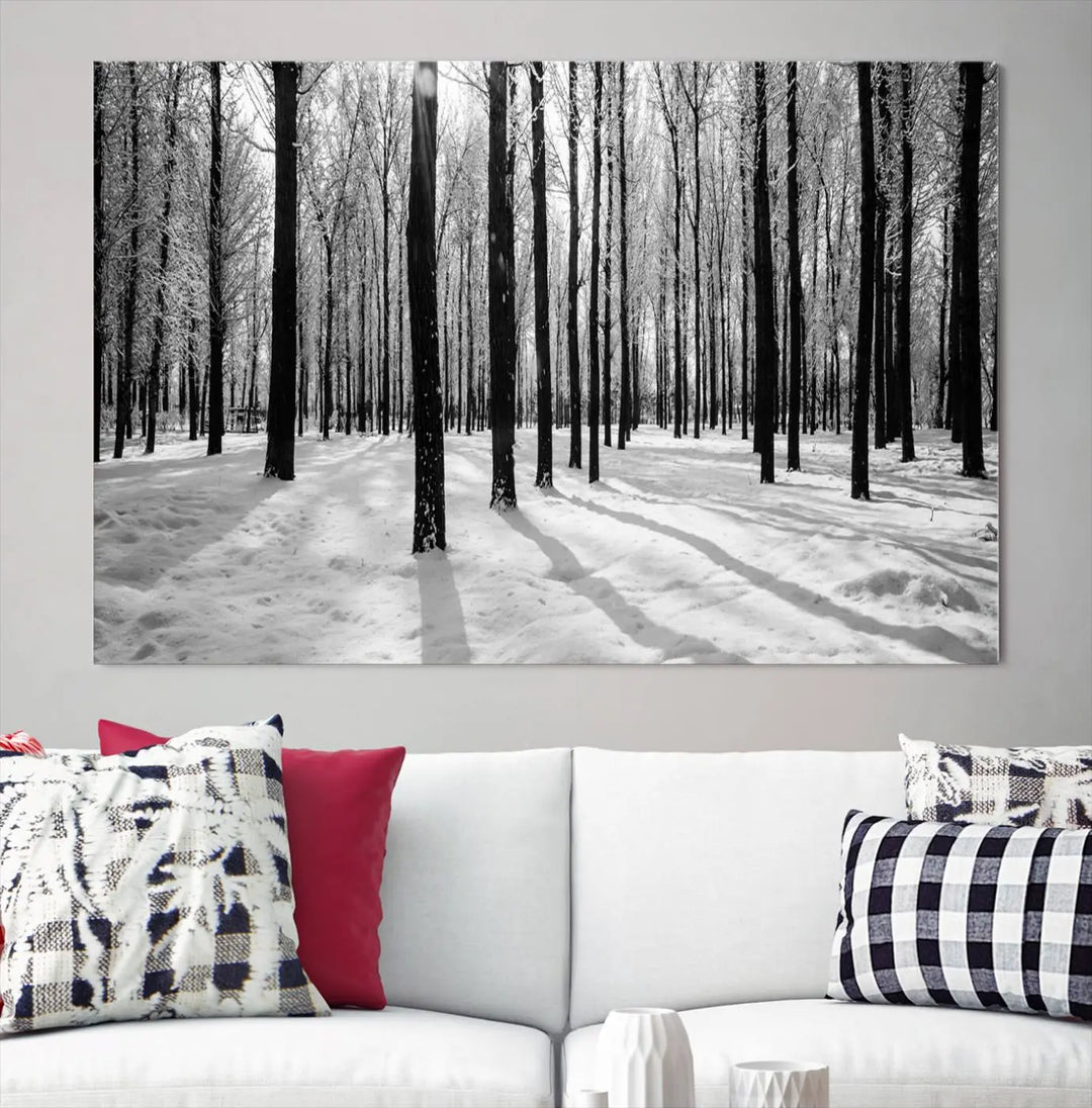 The Winter Forest Wall Art Canvas Print, featuring a snowy forest scene with a UV-protective coating, is displayed in a modern living room.