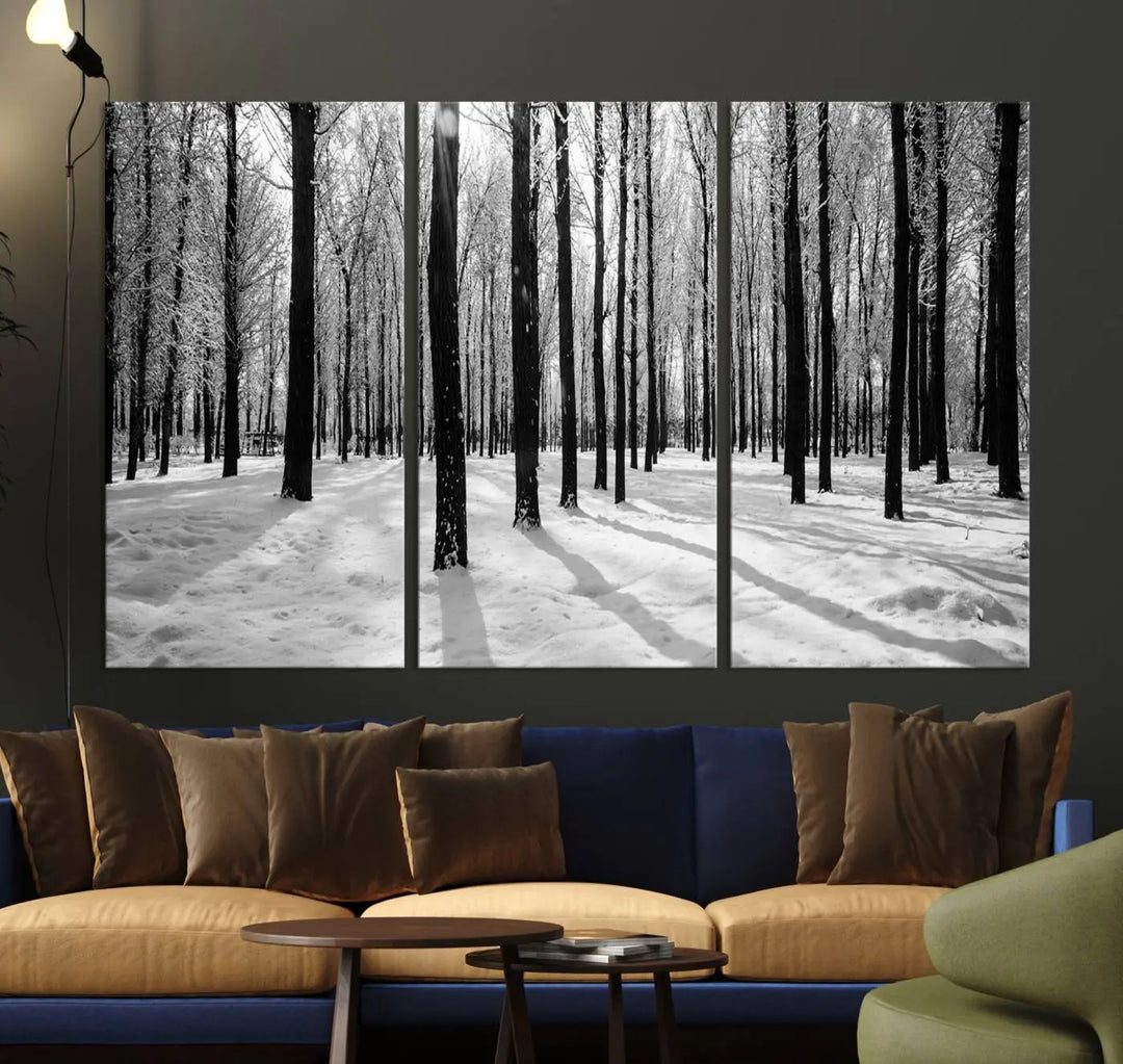 The Winter Forest Wall Art Canvas Print, featuring a snowy forest scene with a UV-protective coating, is displayed in a modern living room.