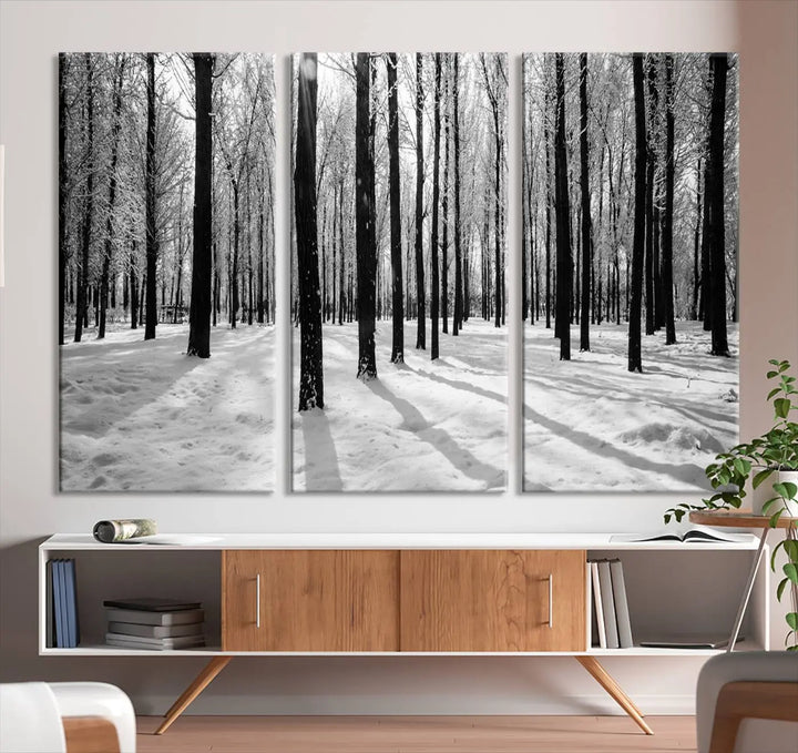 The Winter Forest Wall Art Canvas Print, featuring a snowy forest scene with a UV-protective coating, is displayed in a modern living room.