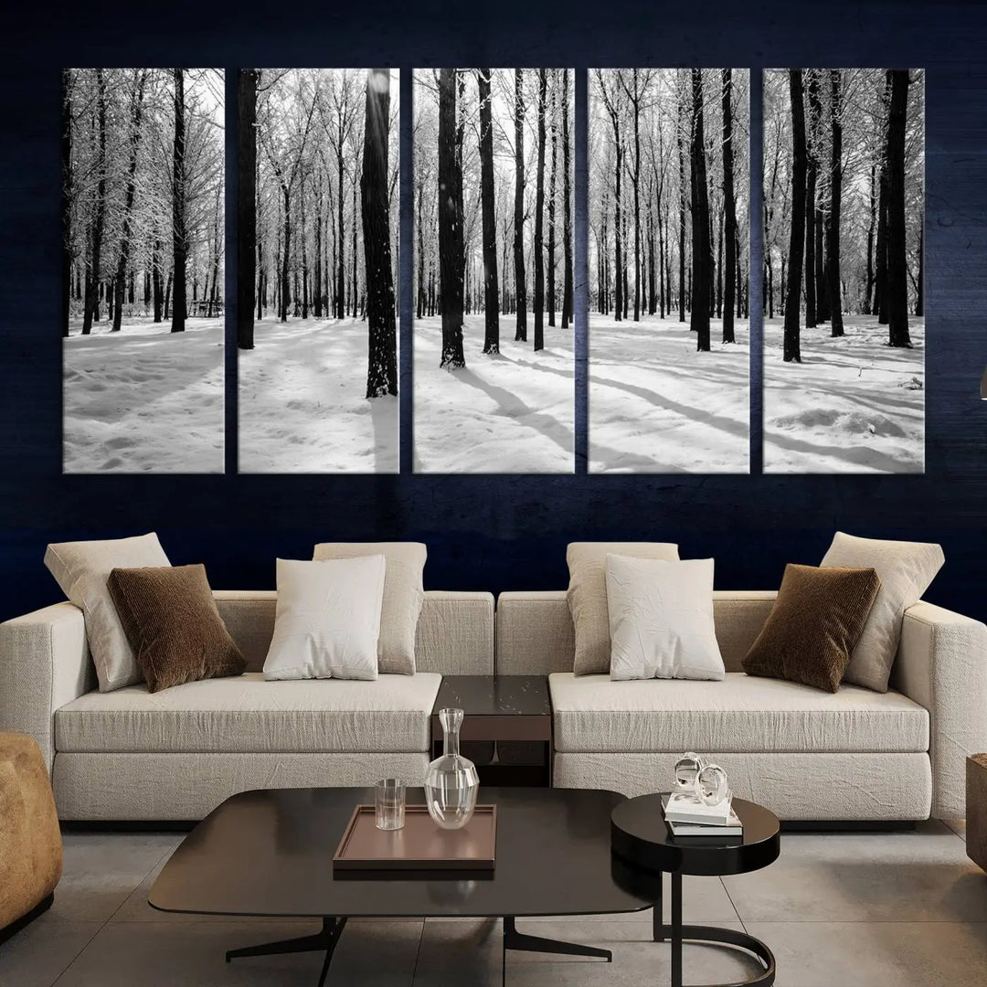 The Winter Forest Wall Art Canvas Print, featuring a snowy forest scene with a UV-protective coating, is displayed in a modern living room.