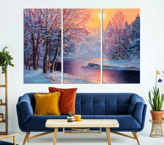 In a cozy living room, you'll find wall art titled "Winter Landscape Painting Wall Art Canvas Print," showcasing a serene snowy river scene at sunset on a museum-quality canvas with gallery-wrapped edges.