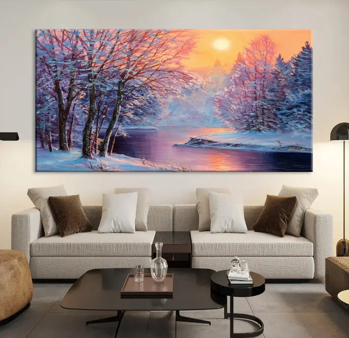 In a cozy living room, you'll find wall art titled "Winter Landscape Painting Wall Art Canvas Print," showcasing a serene snowy river scene at sunset on a museum-quality canvas with gallery-wrapped edges.