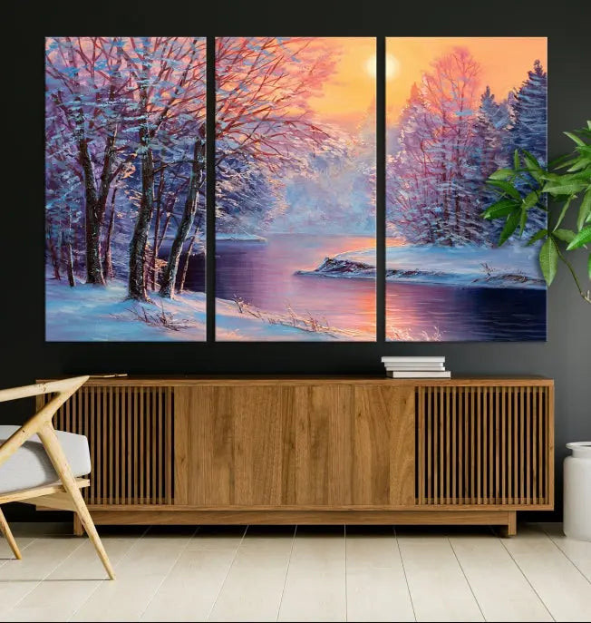 In a cozy living room, you'll find wall art titled "Winter Landscape Painting Wall Art Canvas Print," showcasing a serene snowy river scene at sunset on a museum-quality canvas with gallery-wrapped edges.