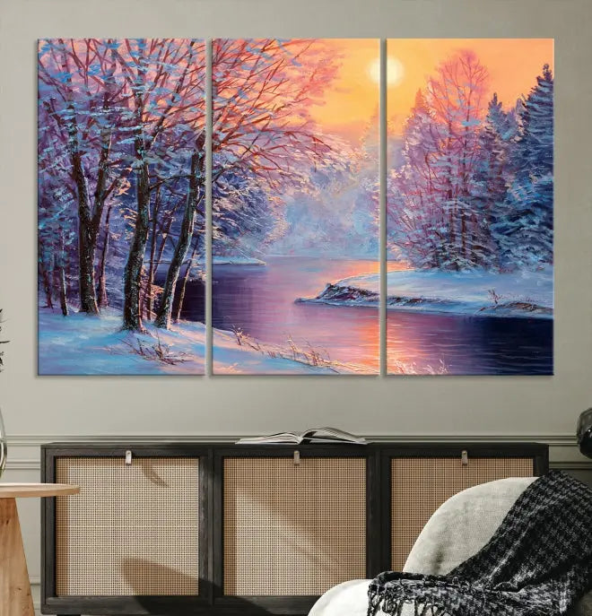 In a cozy living room, you'll find wall art titled "Winter Landscape Painting Wall Art Canvas Print," showcasing a serene snowy river scene at sunset on a museum-quality canvas with gallery-wrapped edges.