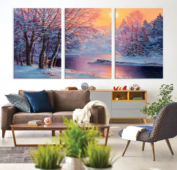 In a cozy living room, you'll find wall art titled "Winter Landscape Painting Wall Art Canvas Print," showcasing a serene snowy river scene at sunset on a museum-quality canvas with gallery-wrapped edges.