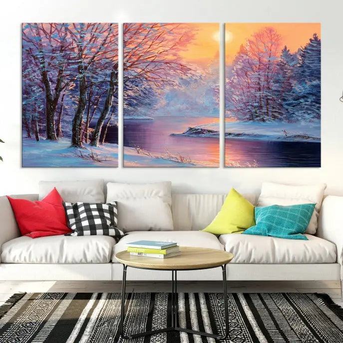 In a cozy living room, you'll find wall art titled "Winter Landscape Painting Wall Art Canvas Print," showcasing a serene snowy river scene at sunset on a museum-quality canvas with gallery-wrapped edges.