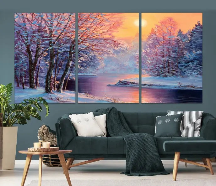 In a cozy living room, you'll find wall art titled "Winter Landscape Painting Wall Art Canvas Print," showcasing a serene snowy river scene at sunset on a museum-quality canvas with gallery-wrapped edges.