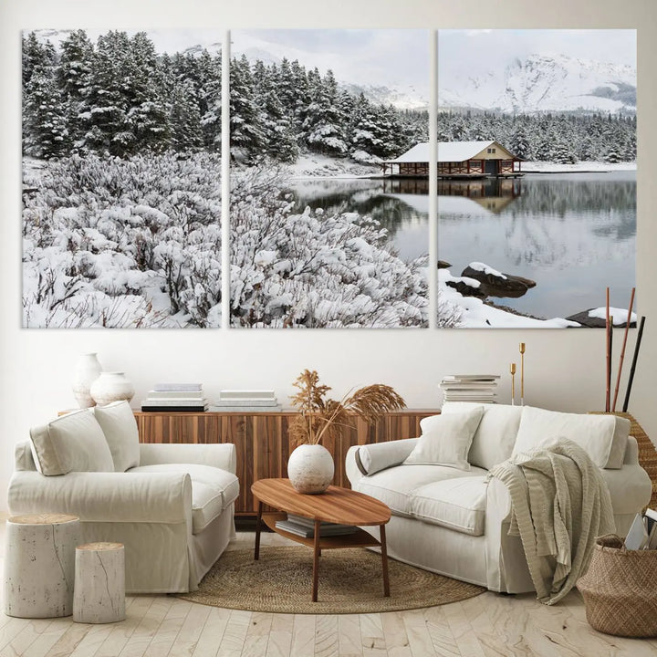 Experience the beauty of winter with the "Cabin by the Lake Canvas Wall Art," showcasing a serene snowy landscape. This rustic nature decor features a cozy cabin nestled amid snow-laden trees, set against a breathtaking mountain view, perfect for enhancing your living room.