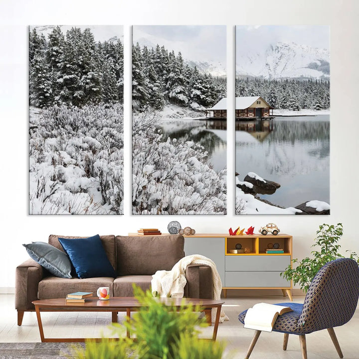 Experience the beauty of winter with the "Cabin by the Lake Canvas Wall Art," showcasing a serene snowy landscape. This rustic nature decor features a cozy cabin nestled amid snow-laden trees, set against a breathtaking mountain view, perfect for enhancing your living room.