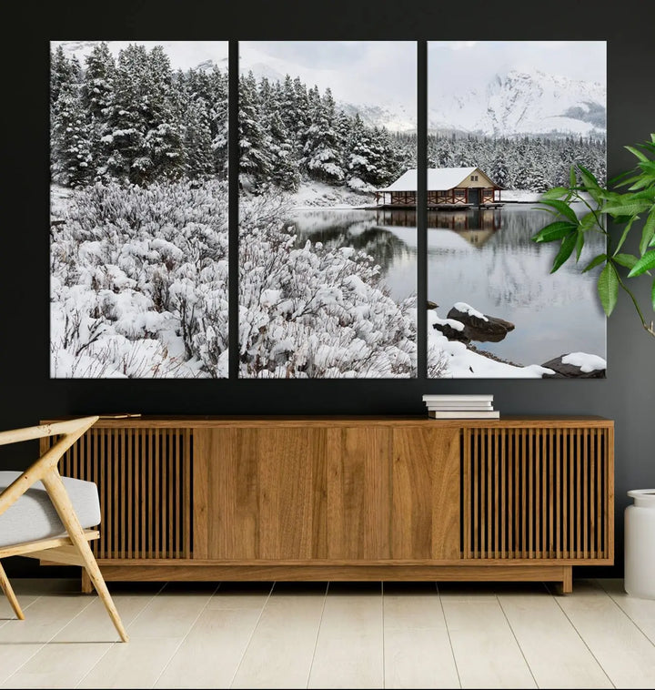 Experience the beauty of winter with the "Cabin by the Lake Canvas Wall Art," showcasing a serene snowy landscape. This rustic nature decor features a cozy cabin nestled amid snow-laden trees, set against a breathtaking mountain view, perfect for enhancing your living room.