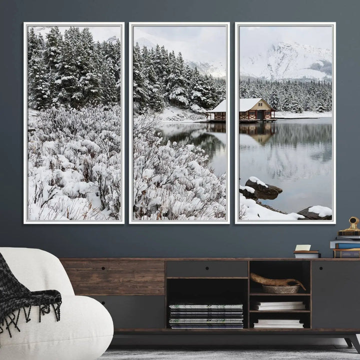 Experience the beauty of winter with the "Cabin by the Lake Canvas Wall Art," showcasing a serene snowy landscape. This rustic nature decor features a cozy cabin nestled amid snow-laden trees, set against a breathtaking mountain view, perfect for enhancing your living room.