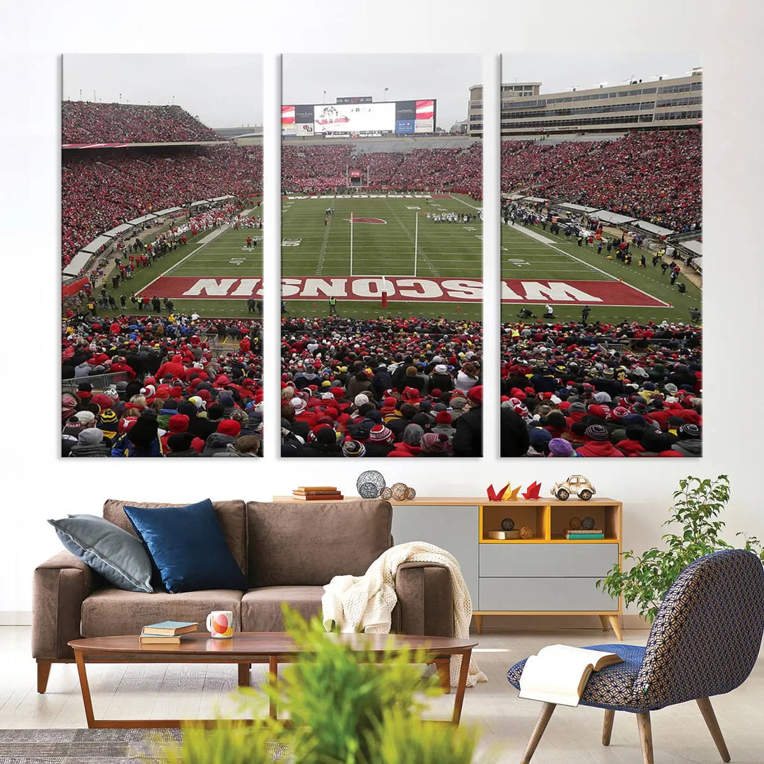 A living room exhibits the premium Wisconsin Badgers Football Team Print - Madison Camp Randall Stadium Wall Art Canvas Print, a triptych displaying an exciting game at Wisconsin. This canvas artwork infuses the space with vibrant energy.