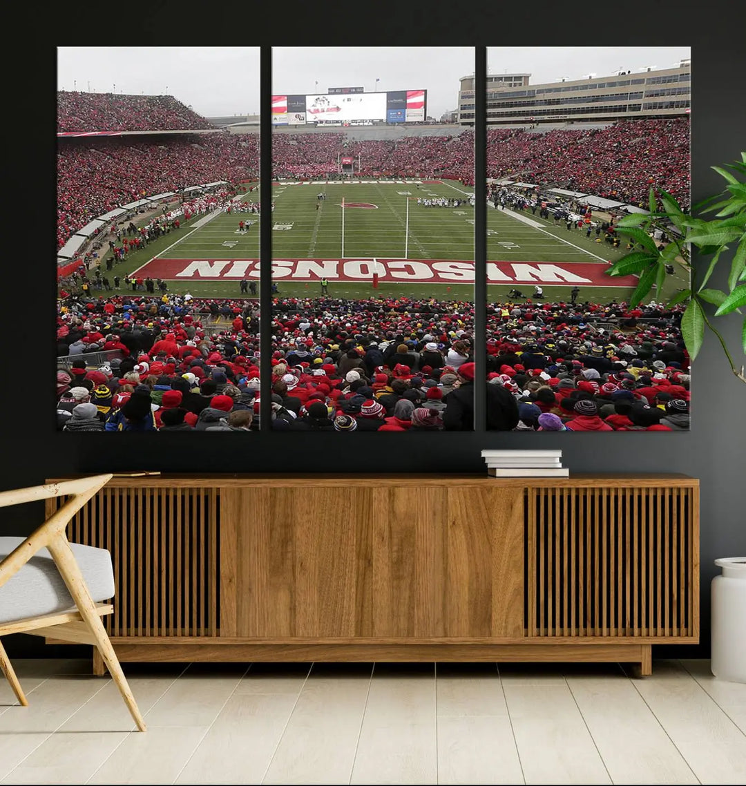 A living room exhibits the premium Wisconsin Badgers Football Team Print - Madison Camp Randall Stadium Wall Art Canvas Print, a triptych displaying an exciting game at Wisconsin. This canvas artwork infuses the space with vibrant energy.