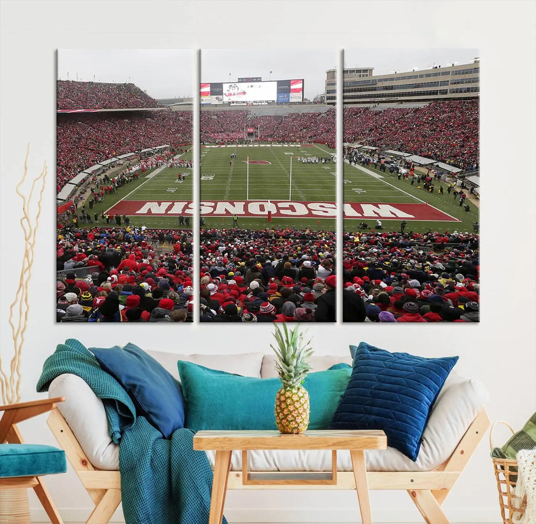 A living room exhibits the premium Wisconsin Badgers Football Team Print - Madison Camp Randall Stadium Wall Art Canvas Print, a triptych displaying an exciting game at Wisconsin. This canvas artwork infuses the space with vibrant energy.