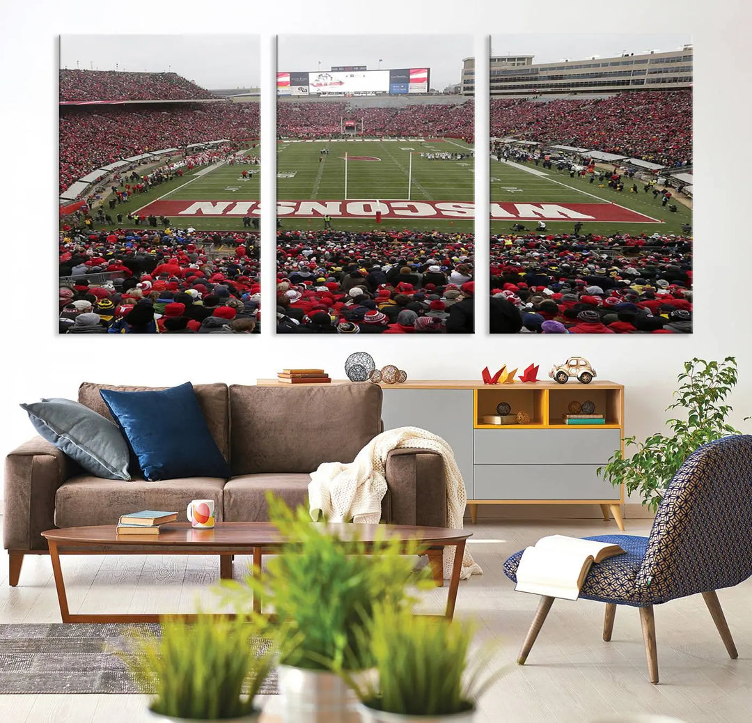 A living room exhibits the premium Wisconsin Badgers Football Team Print - Madison Camp Randall Stadium Wall Art Canvas Print, a triptych displaying an exciting game at Wisconsin. This canvas artwork infuses the space with vibrant energy.