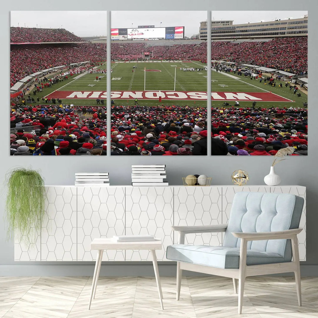 A living room exhibits the premium Wisconsin Badgers Football Team Print - Madison Camp Randall Stadium Wall Art Canvas Print, a triptych displaying an exciting game at Wisconsin. This canvas artwork infuses the space with vibrant energy.