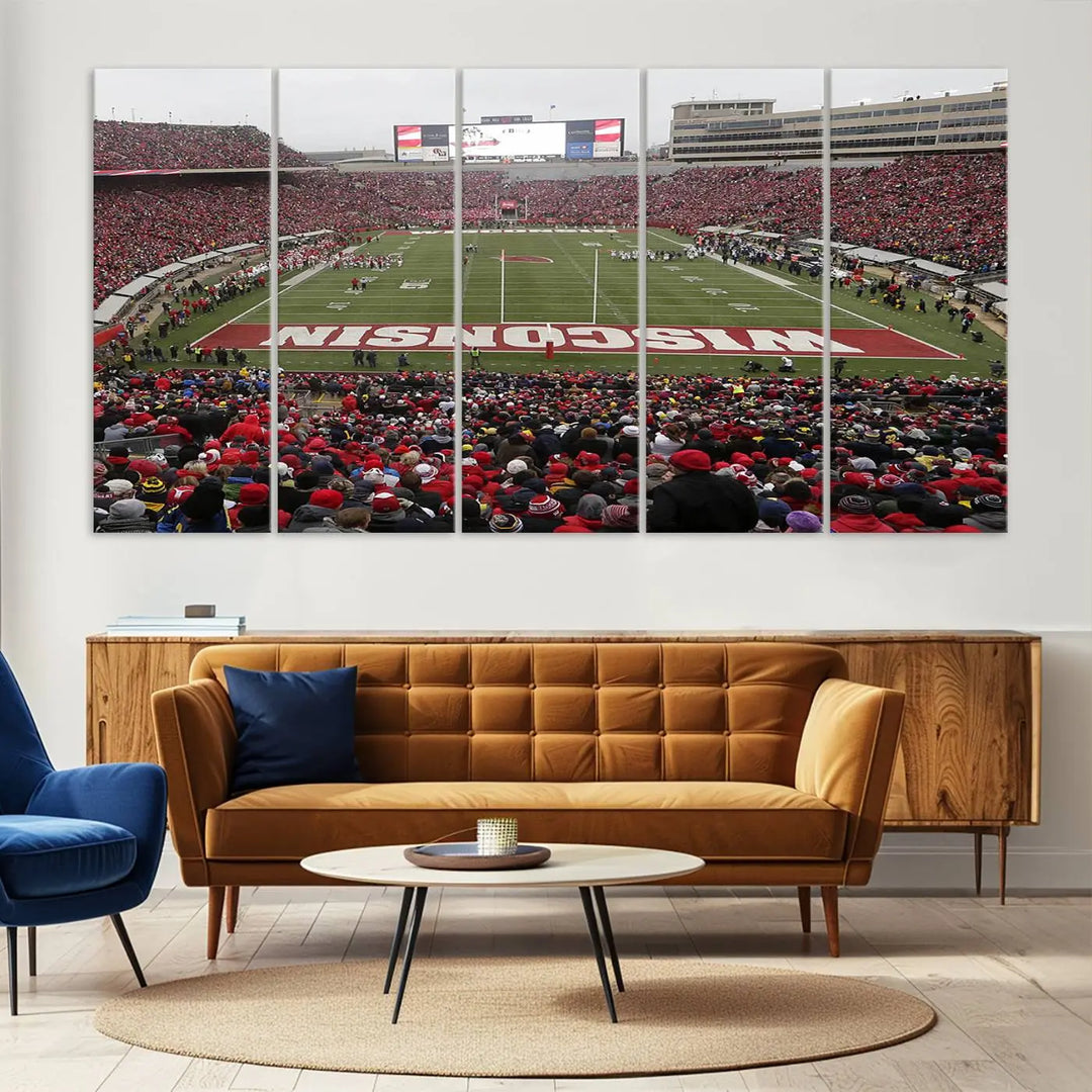 A living room exhibits the premium Wisconsin Badgers Football Team Print - Madison Camp Randall Stadium Wall Art Canvas Print, a triptych displaying an exciting game at Wisconsin. This canvas artwork infuses the space with vibrant energy.