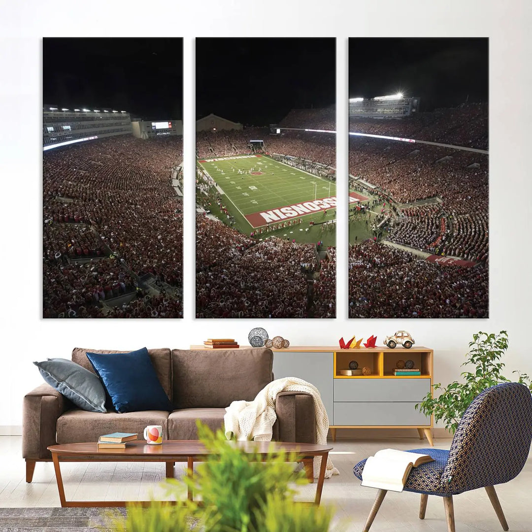 The Madison Camp Randall Stadium wall art canvas print showcases the Wisconsin Badgers football team, capturing a packed stadium at night. This three-panel piece is handmade in the USA.