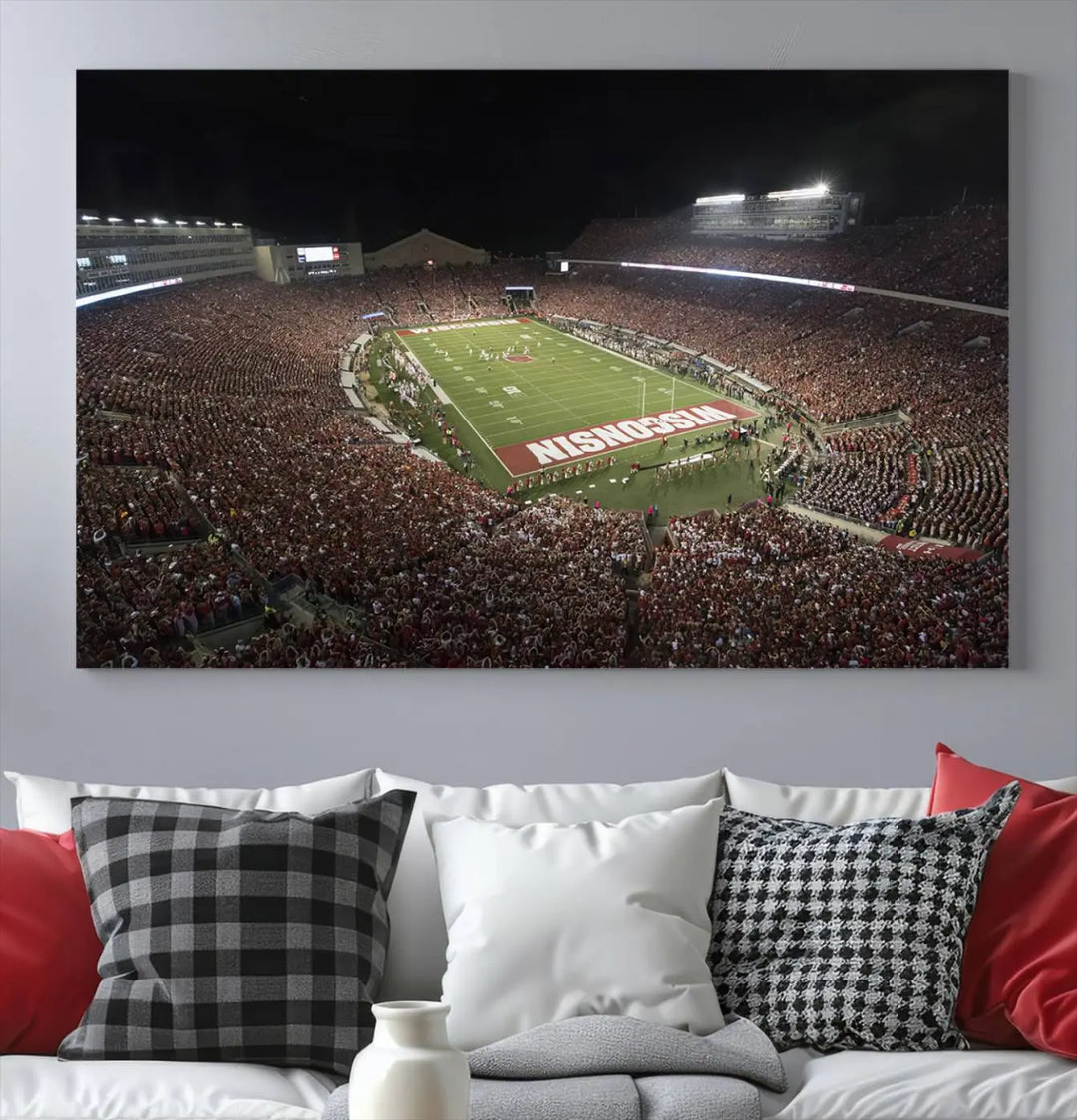 The Madison Camp Randall Stadium wall art canvas print showcases the Wisconsin Badgers football team, capturing a packed stadium at night. This three-panel piece is handmade in the USA.