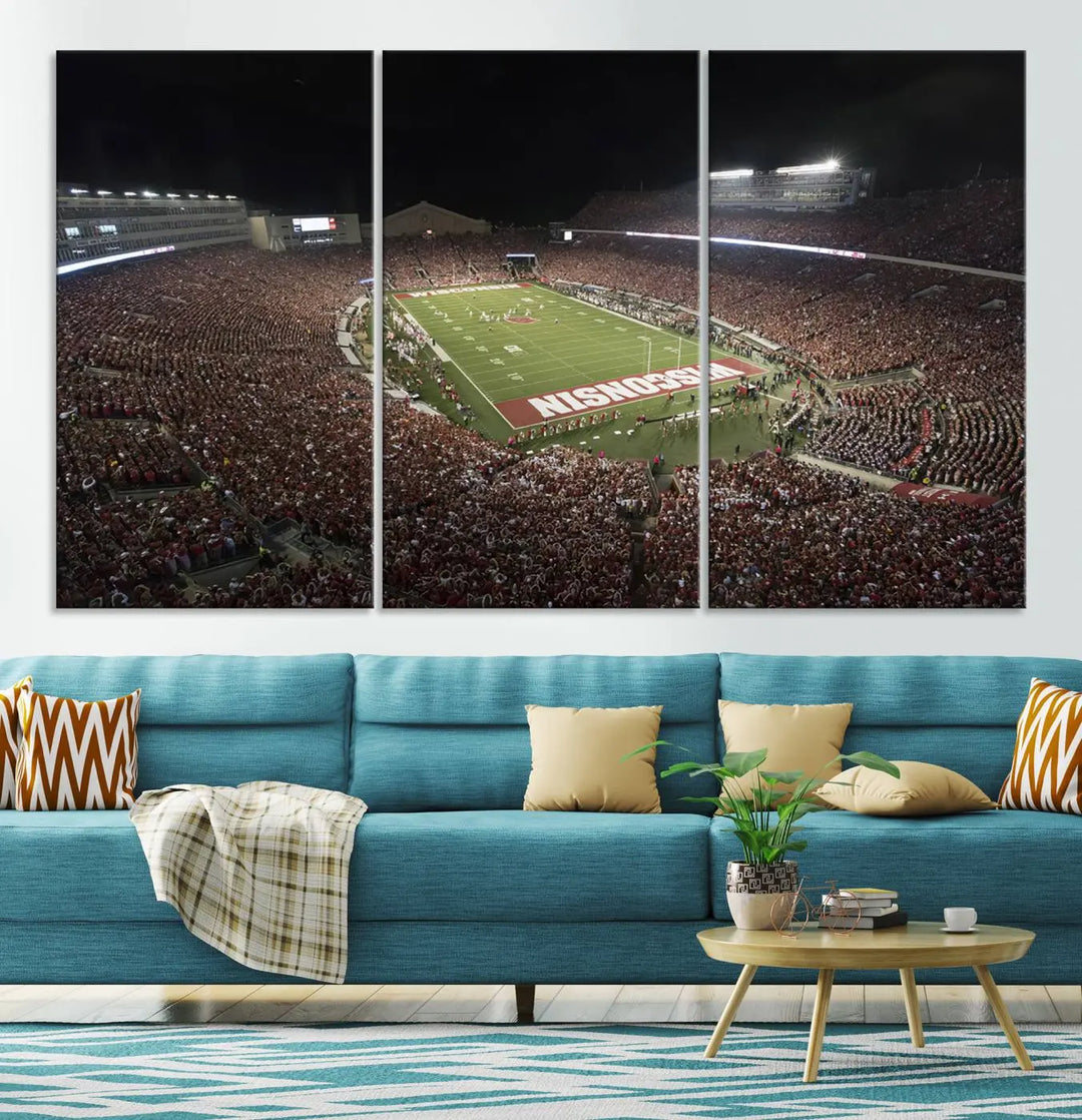 The Madison Camp Randall Stadium wall art canvas print showcases the Wisconsin Badgers football team, capturing a packed stadium at night. This three-panel piece is handmade in the USA.