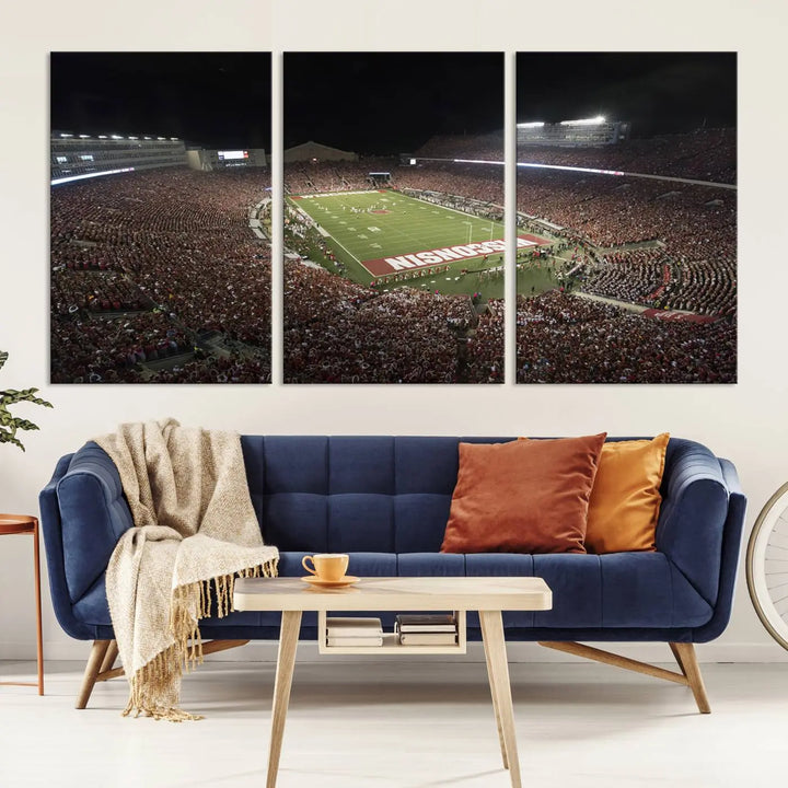 The Madison Camp Randall Stadium wall art canvas print showcases the Wisconsin Badgers football team, capturing a packed stadium at night. This three-panel piece is handmade in the USA.