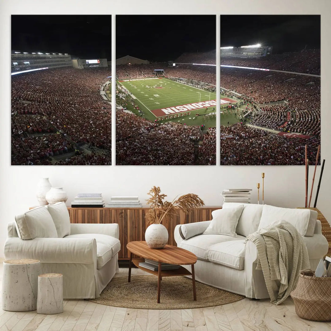 The Madison Camp Randall Stadium wall art canvas print showcases the Wisconsin Badgers football team, capturing a packed stadium at night. This three-panel piece is handmade in the USA.