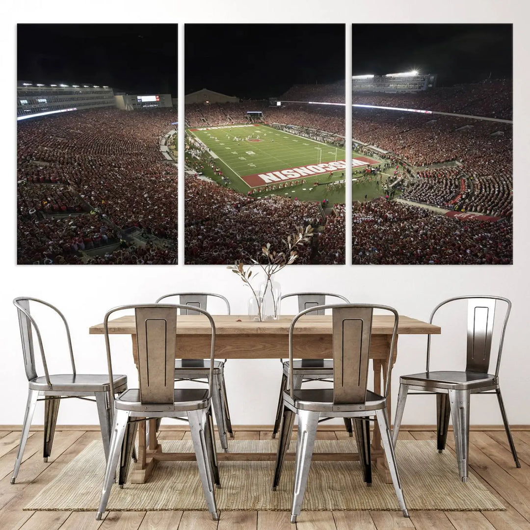 The Madison Camp Randall Stadium wall art canvas print showcases the Wisconsin Badgers football team, capturing a packed stadium at night. This three-panel piece is handmade in the USA.