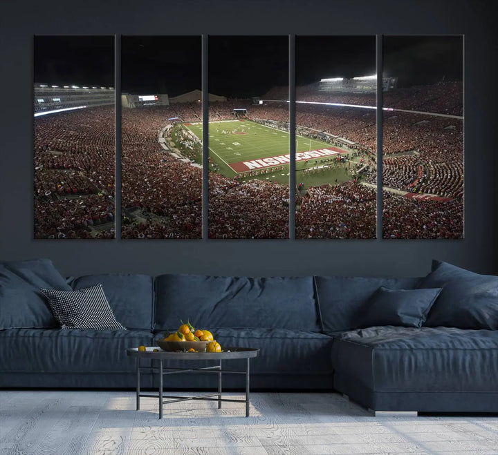 The Madison Camp Randall Stadium wall art canvas print showcases the Wisconsin Badgers football team, capturing a packed stadium at night. This three-panel piece is handmade in the USA.