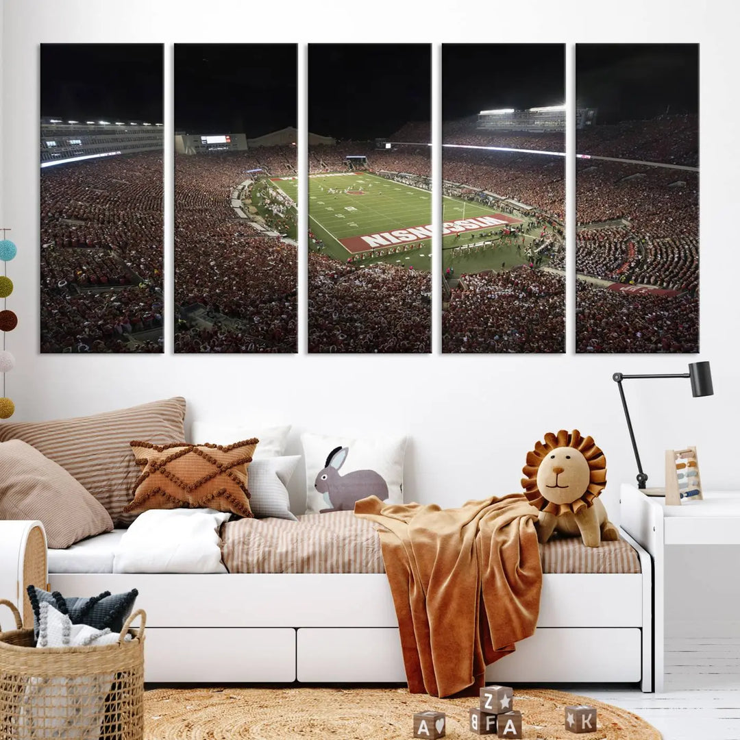 The Madison Camp Randall Stadium wall art canvas print showcases the Wisconsin Badgers football team, capturing a packed stadium at night. This three-panel piece is handmade in the USA.