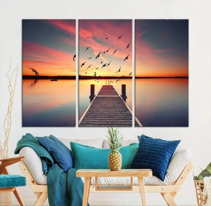 The Wood Bridge and Sunset Wall Art Canvas Print showcases a tranquil sunset scene featuring a wooden dock, soaring birds, and a vibrant sky. It comes ready to hang.