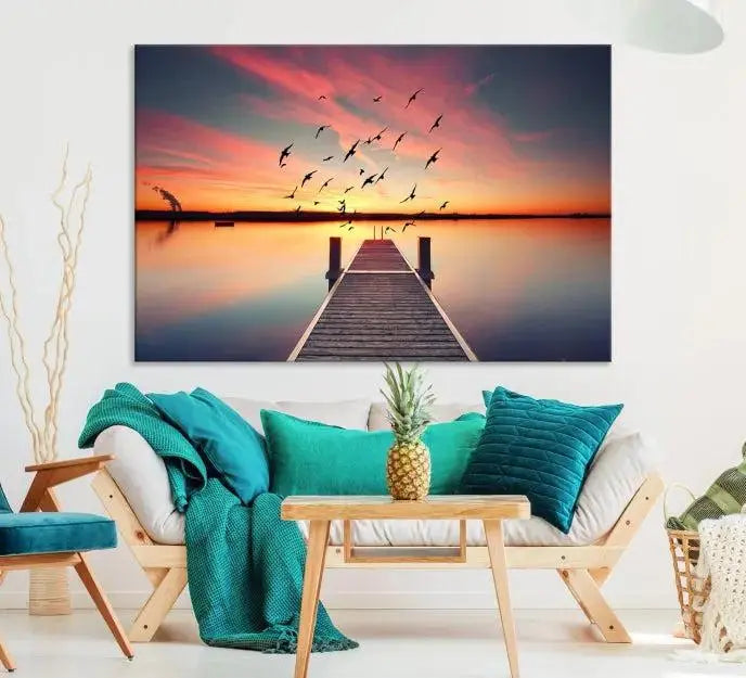 The Wood Bridge and Sunset Wall Art Canvas Print showcases a tranquil sunset scene featuring a wooden dock, soaring birds, and a vibrant sky. It comes ready to hang.