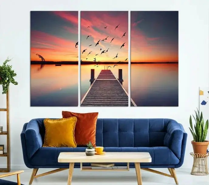 The Wood Bridge and Sunset Wall Art Canvas Print showcases a tranquil sunset scene featuring a wooden dock, soaring birds, and a vibrant sky. It comes ready to hang.