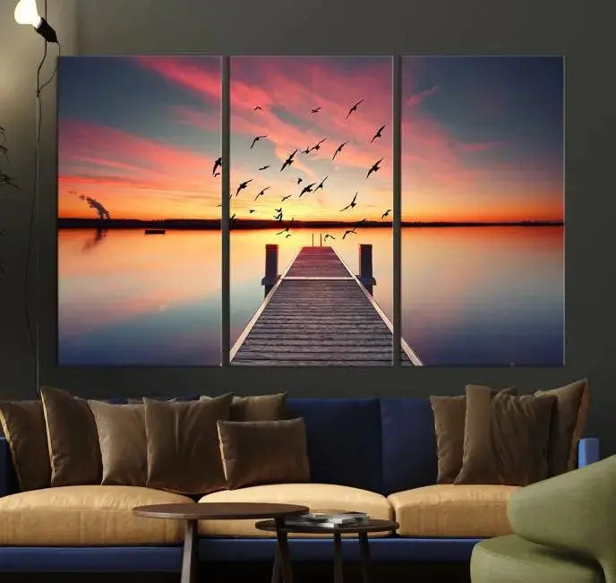 The Wood Bridge and Sunset Wall Art Canvas Print showcases a tranquil sunset scene featuring a wooden dock, soaring birds, and a vibrant sky. It comes ready to hang.