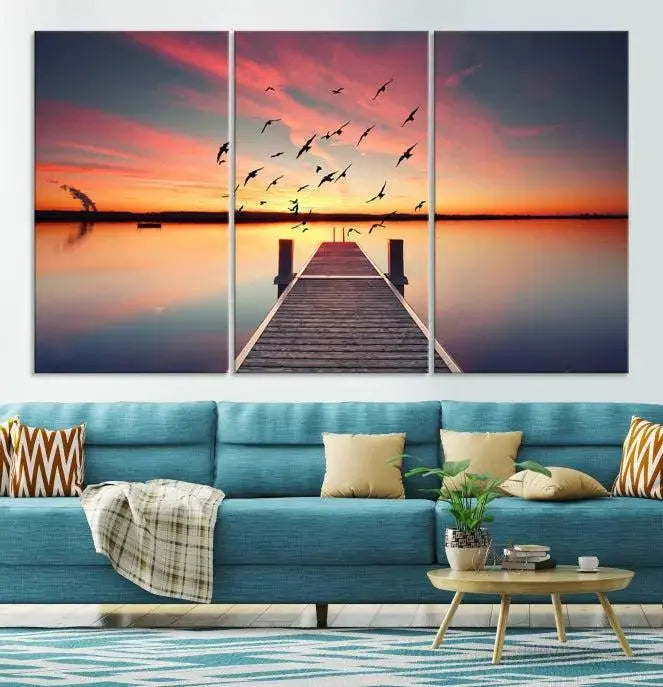 The Wood Bridge and Sunset Wall Art Canvas Print showcases a tranquil sunset scene featuring a wooden dock, soaring birds, and a vibrant sky. It comes ready to hang.