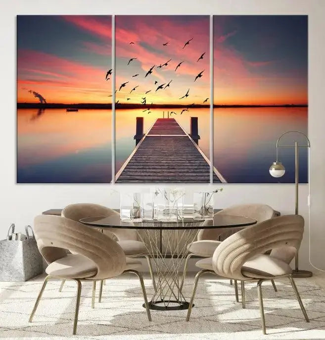 The Wood Bridge and Sunset Wall Art Canvas Print showcases a tranquil sunset scene featuring a wooden dock, soaring birds, and a vibrant sky. It comes ready to hang.