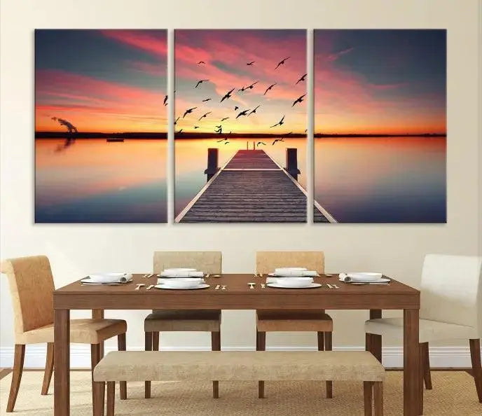 The Wood Bridge and Sunset Wall Art Canvas Print showcases a tranquil sunset scene featuring a wooden dock, soaring birds, and a vibrant sky. It comes ready to hang.